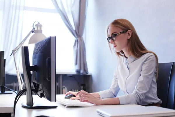 A woman working on a computer with Earn Learning, automating her digital products sales.